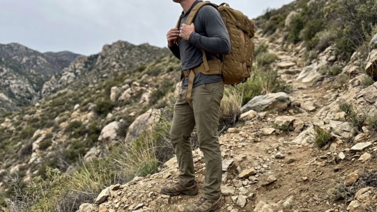 Side view of man pausing on hill with weighted backpack showing How to Breathe Properly while Rucking.