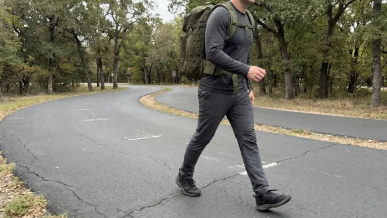 Rucking 10k steps shown by man walking with weighted backpack on loop trail emphasizing high daily step count.